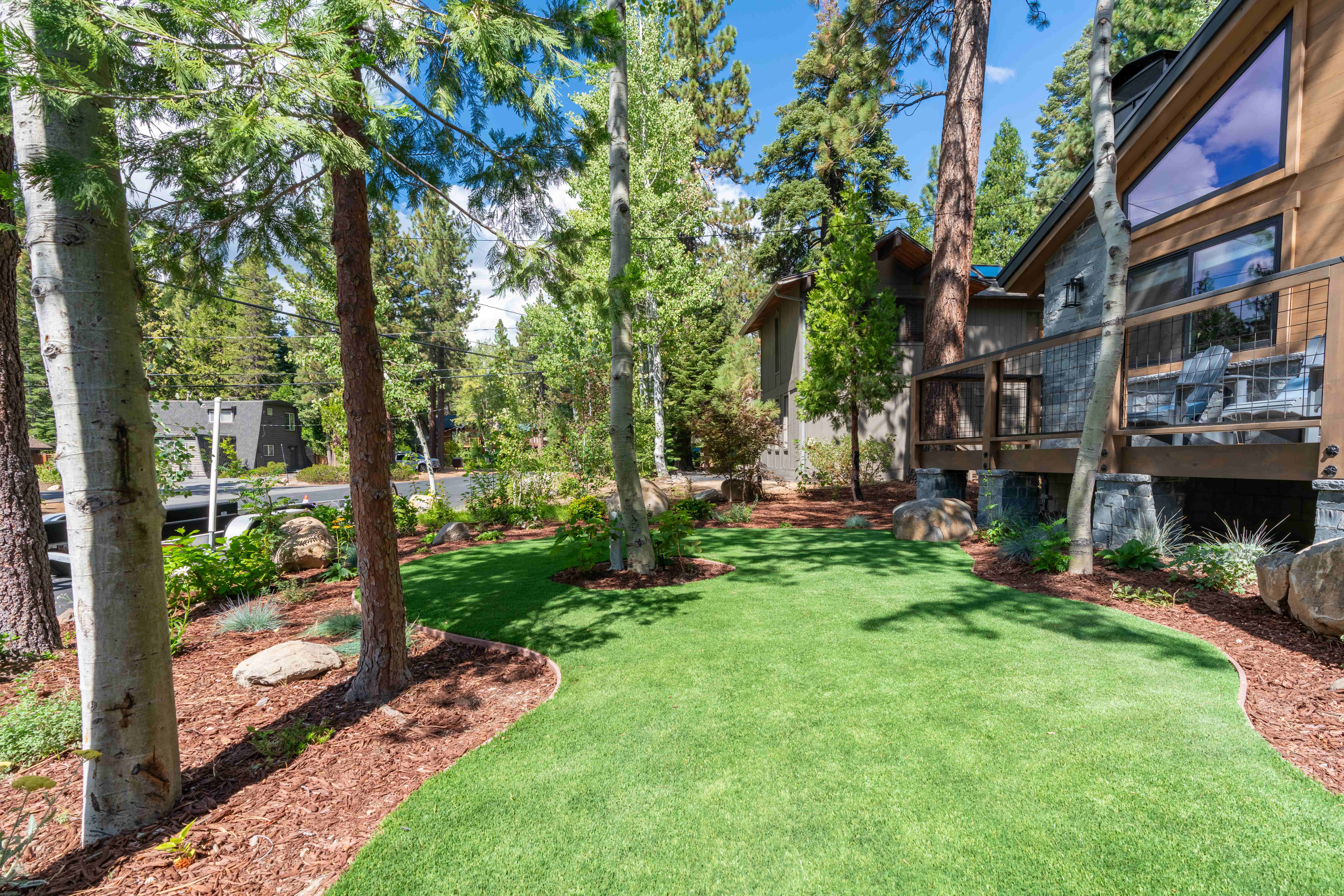 Lawn and planting design with trees and stone accents in Tahoe